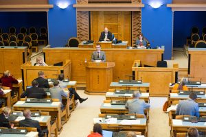 Istungi juhataja oma töölaua taga, taamal valitsusliikmete ja presidendi kohad